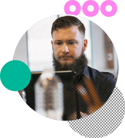 A man with a beard working on a laptop