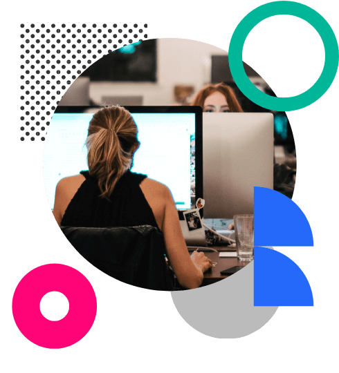 A woman with her back to the camera working at a large computer screen